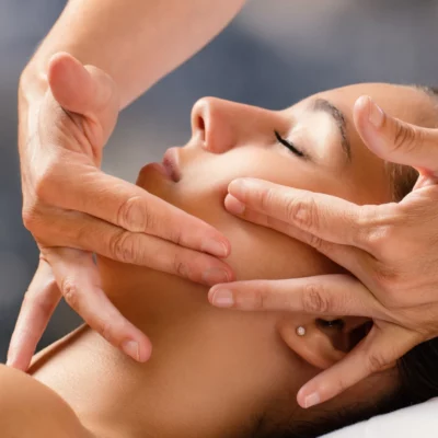 Un visage de femme qui se fait masser de manière technique par une professionnelle du soin visage Kinéplastie. Un soin inventé il y a 75 ans et dont Vanessa Paradis vante les mérites pour préserver sa jeunesse